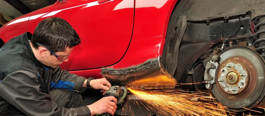 Technician performing collision body repair on red vehicle in Pharr TX