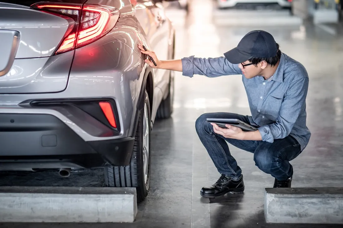 Technician performing quality inspection on repaired vehicle